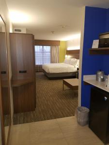 a hotel room with a bedroom with a bed at Holiday Inn Express Rolla, an IHG Hotel in Rolla