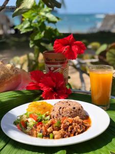 un piatto di cibo e un bicchiere di succo d'arancia di Hospedaje Yarisnori a Bocas del Toro