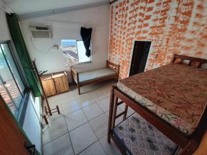 a bedroom with a bed and a chair in a room at Hostel Tabapiri in Porto Seguro