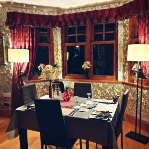 a dining room with a table with chairs and lamps at Bogenraith House in Banchory