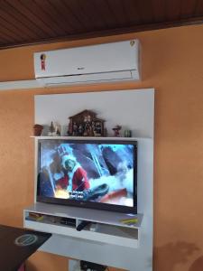 a flat screen tv sitting on a white shelf at Casa na praia de maresias em condomínio na avenida da praia com piscina aquecida in Maresias