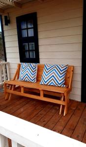 a wooden bench sitting on the porch of a house at Ocean Paradise 2 in Punta Del Diablo