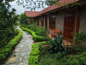 einen Steinweg neben einem Haus mit einem Gebäude in der Unterkunft Tam Coc Melody Homestay in Ninh Bình