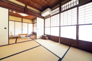 阿美弥 一日一組様限定 في كيوتو: غرفة فارغة بنوافذ كبيرة وطاولة