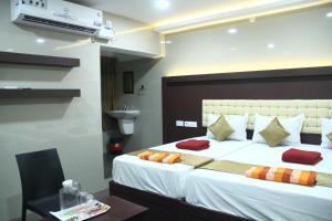 a bedroom with a large white bed with red pillows at Hotel Temple Tower Rameswaram in Rāmeswaram