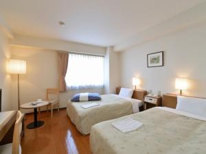 um quarto de hotel com duas camas e uma janela em Sapporo Clark Hotel em Sapporo