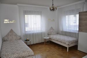 a bedroom with two beds and a chandelier at Super zentral und dennoch idyllisch und erholsam in Dreieich