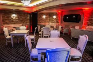 a restaurant with tables and chairs and a tv at Hotel ToacaBellevue in Gura Humorului