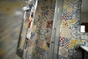 uma casa de banho com azulejos coloridos na parede em B&B Corte Casole em Gallipoli