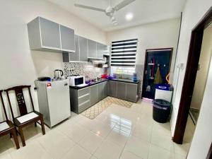 eine Küche mit einem Kühlschrank, einem Tisch und einem Stuhl in der Unterkunft ST2167 Arfa Permata Homestay in Masjid Tanah