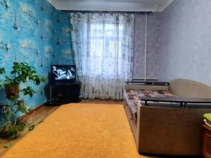 クロプィウヌィーツィクィイにあるБольшая Перспективная 46のベッドとテレビが備わる客室です。