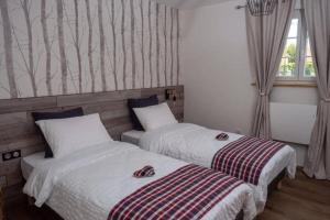2 camas en una habitación de hotel con ventana en Gîte L'Ecrin du Ried "COSY", en Artolsheim