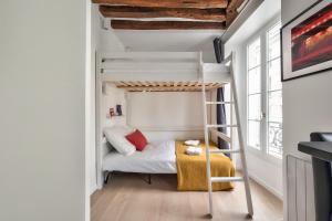 a small bedroom with a bunk bed and a ladder at Lovely Mezzanine Studio in the Heart of Paris 3M in Paris