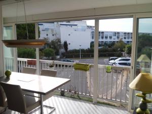 a balcony with a table and a view of a parking lot at APPART MER CALME ET ENSOLEILLEE in Le Grau-du-Roi