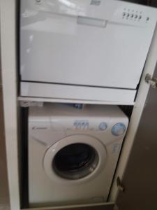 uma máquina de lavar roupa com uma caixa em cima em APPART MER CALME ET ENSOLEILLEE em Le Grau-du-Roi