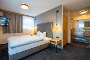 a hotel room with a large bed and a television at MAXAlpin Appartements in Längenfeld