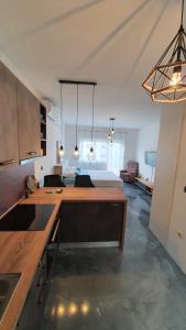 a kitchen with a counter top and a living room at Slow motion in Kaštela