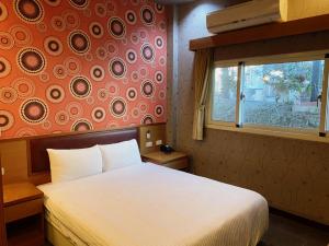1 dormitorio con cama blanca y ventana en 自在旅墅山莊 en Guoxing
