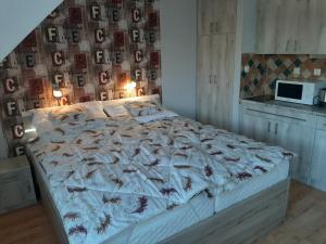 a bedroom with a large bed with a wall with pictures at Elit Apartman in Hajdúszoboszló