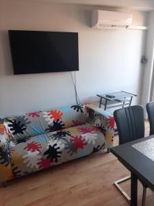 a living room with a couch and a flat screen tv at Elit Apartman in Hajdúszoboszló