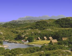 an aerial view of a mountain with houses and a river at Lochinver Holiday Lodges & Cottages in Lochinver