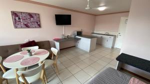 Cairns NorthにあるHoliday Lodge Apartmentのダイニングルーム、キッチン(テーブル、椅子付)