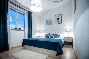 Un dormitorio blanco con una cama azul y una ventana en Beach Suite Nina, en Rab