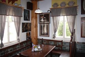 uma sala de jantar com uma mesa e duas janelas em Rodinný penzion Dřevěnka-Kulturni Pamatka em Bozkovska