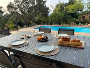 a table with food on it next to a pool at VILLA ISULA by Intendance Excellency in Sainte-Lucie de Porto-Vecchio