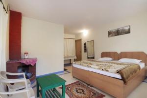 um quarto com uma cama grande e um banco verde em Janardan Resort Pangot Nainital em Nainital