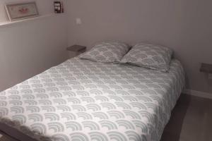 un lit avec deux oreillers dessus dans une chambre dans l'établissement Logement entier 4 personnes Villefranche sur Saone, à Villefranche-sur-Saône