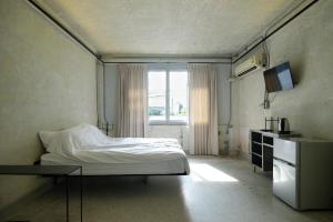 a bedroom with a white bed and a window at EP1 shophouse in Bangkok
