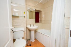 a bathroom with a toilet and a sink and a bath tub at DJ Suites The Element in Manchester