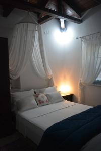 1 dormitorio con cama blanca y cortinas blancas en Petrinο Katochori, en Katokhórion