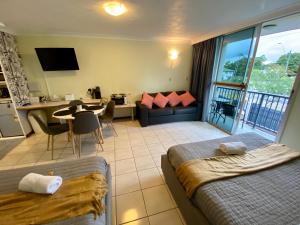 Cairns NorthにあるHoliday Lodge Apartmentのベッド2台、リビングルーム、キッチンが備わる客室です。