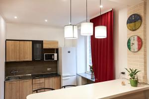 a kitchen with a white refrigerator and a red curtain at Babylon Apartments On Soborna in Rivne