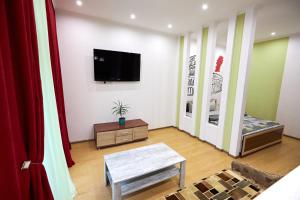 a living room with a flat screen tv on a wall at Babylon Apartments On Soborna in Rivne