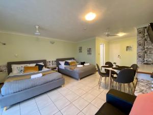 Cairns NorthにあるHoliday Lodge Apartmentのベッド2台とテーブルとソファのある寝室 +21枚の写真
