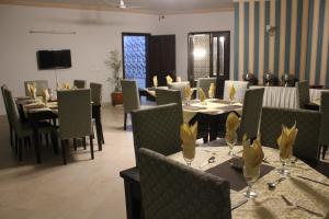 a dining room with tables and chairs and a television at Royal Luxus Guest House in Islamabad