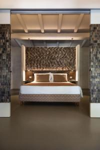 una camera con un grande letto con un muro di mattoni di Stazzo Lu Ciaccaru a Arzachena
