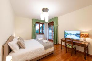 a bedroom with a bed and a desk with a television at 3 Amici al Castello in Verona +18 photos