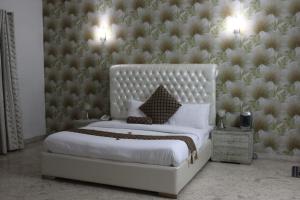 a bedroom with a large white bed with a wall at Royal Luxus Guest House in Islamabad +25 photos