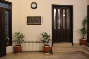 a house with potted plants and a black door at Royal Luxus Guest House in Islamabad
