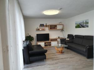 sala de estar con sofá y TV en Ferienwohnung Vikolisa, en Bad Schonborn