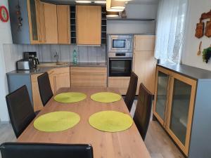 una cocina con una mesa de madera con círculos amarillos. en Ferienwohnung Vikolisa, en Bad Schonborn