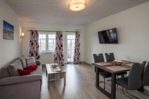 a living room with a couch and a dining room table at Ferienwohnung Nordseegrill in Borkum