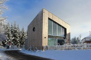 a house in the snow with a fence at Apartment Monolith Black Forest in Schonach