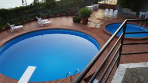 an overhead view of a large blue swimming pool at WHITE LOTUS Apartment in Taormina