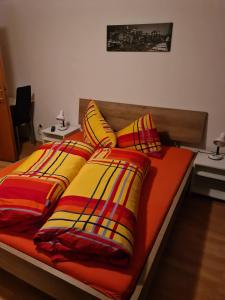 a bed with colorful blankets and pillows on it at Pension Weber in Gries im Sellrain