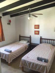 Un dormitorio con dos camas y un ventilador de techo. en CALA SERENA BEACH 5, en Cala Serena